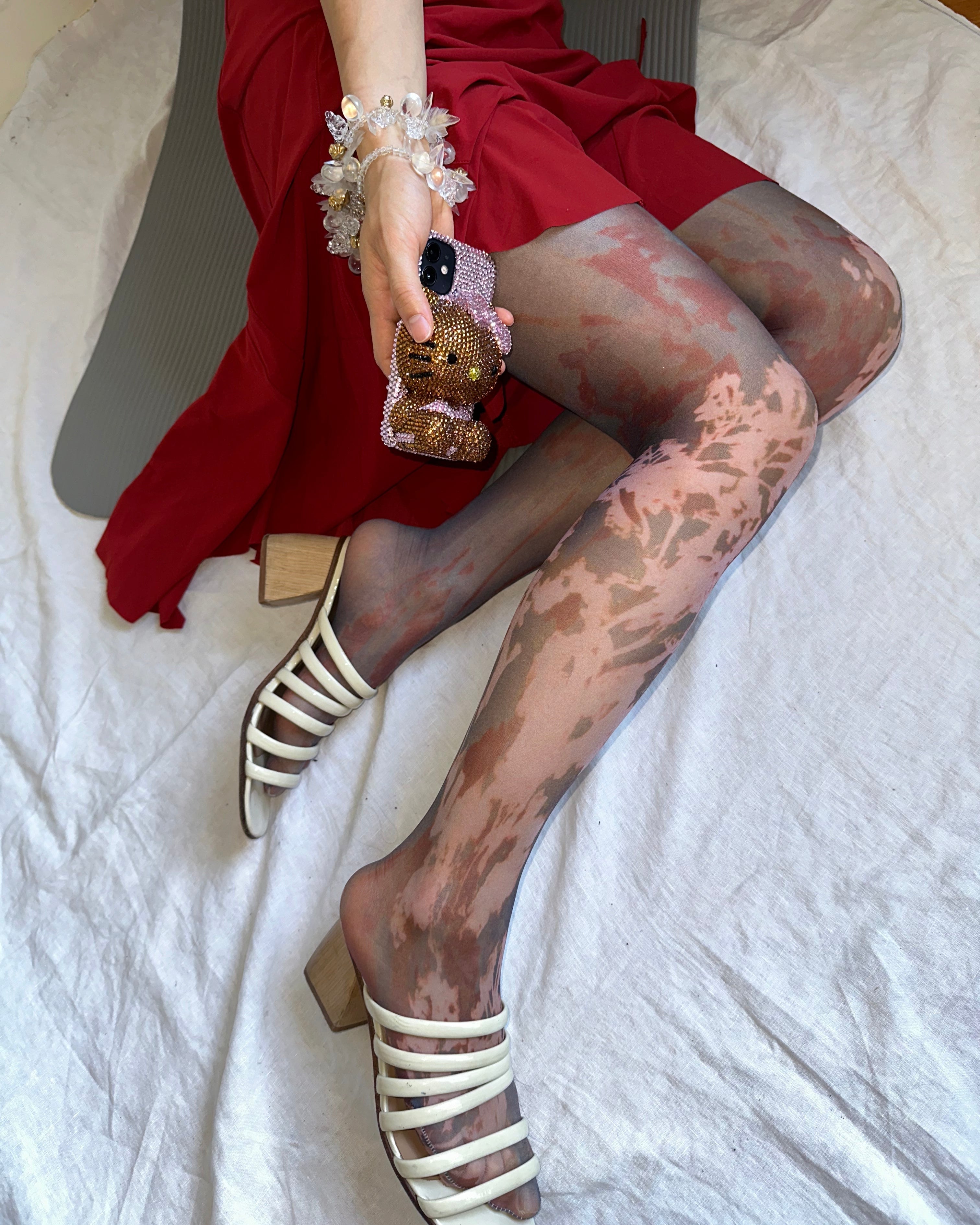 digital printed sheer tights with hello kitty phone case and paloma wool sandals