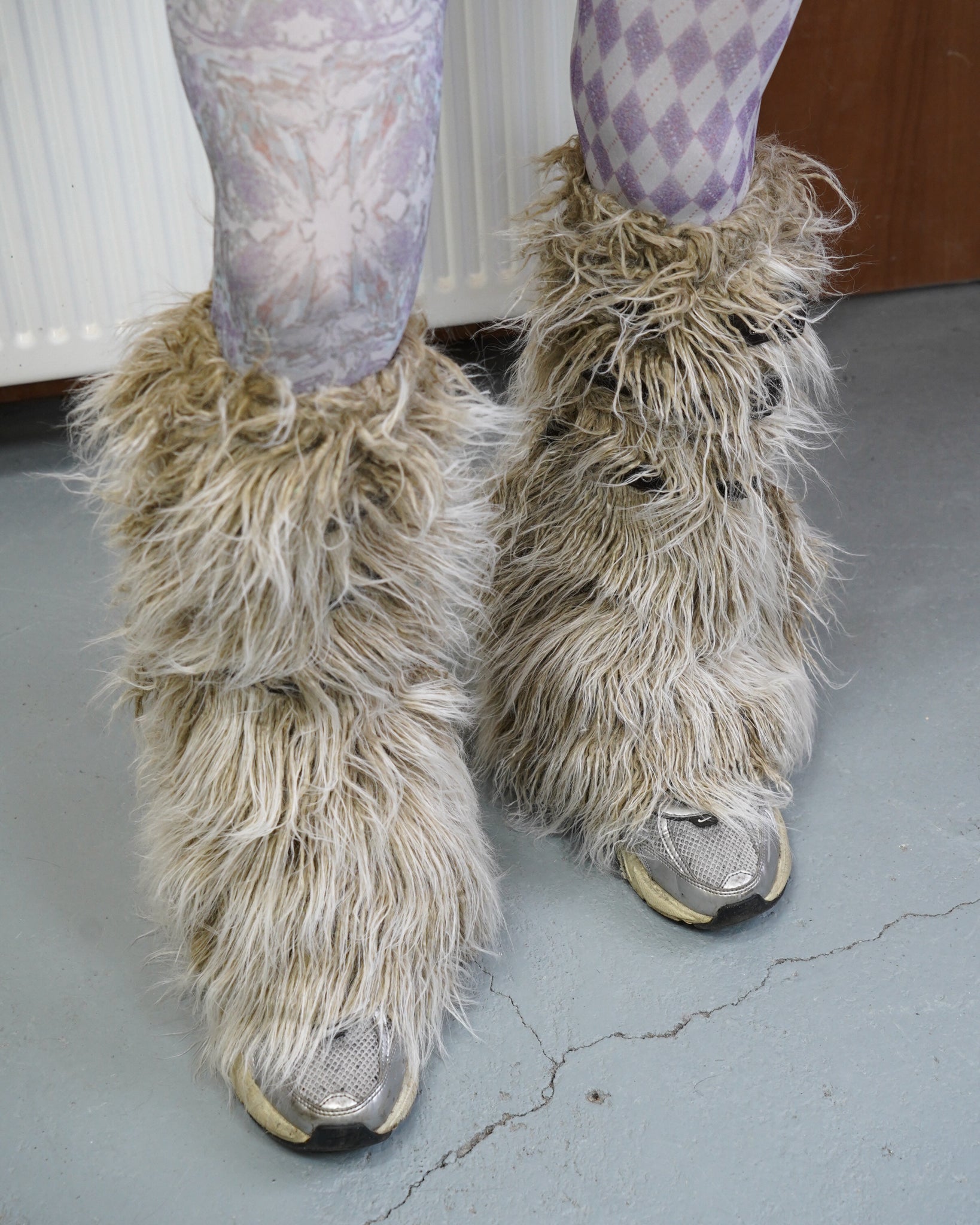 beige leg warmers with purple tights and nike trainers