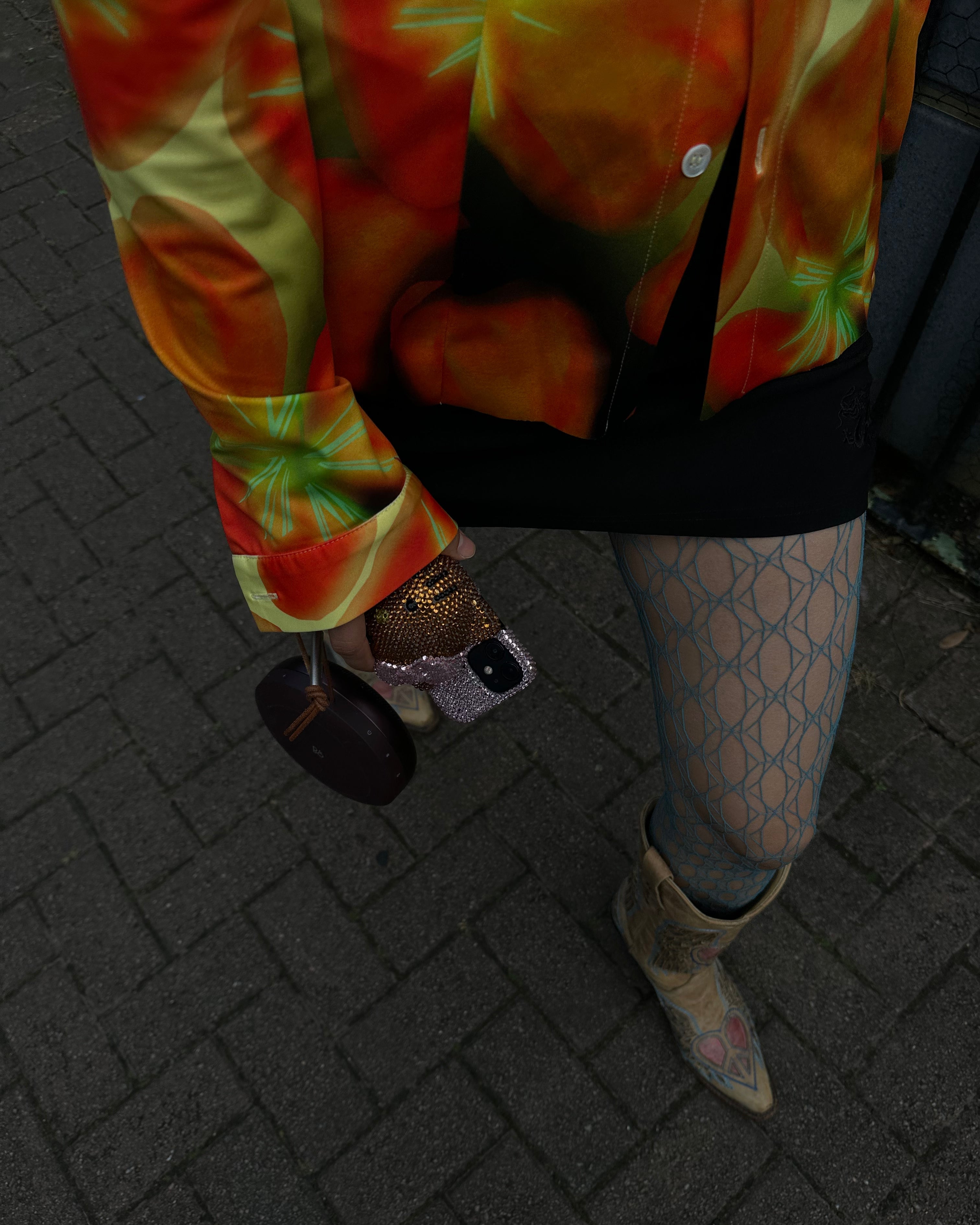 blue fishnet tights with hello kitty phone case and cowboy boots